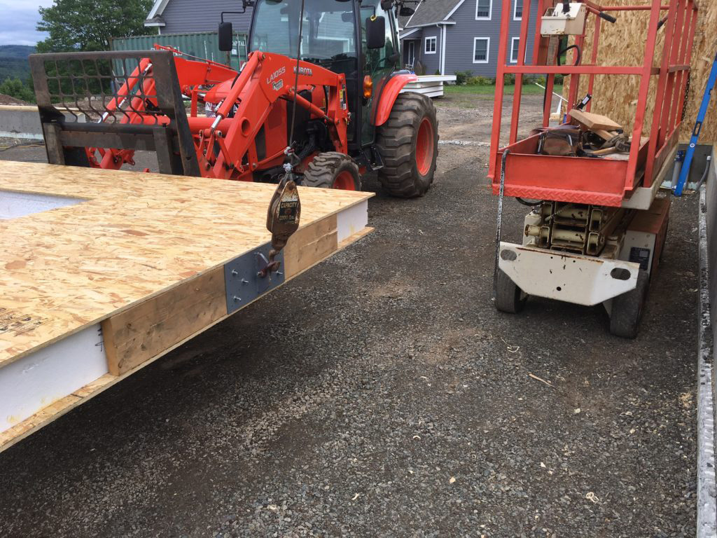 Installation with a tractor of a SIPs panel for a garage in New York